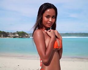 Putri Cinta stripping on a beautiful tropical beach